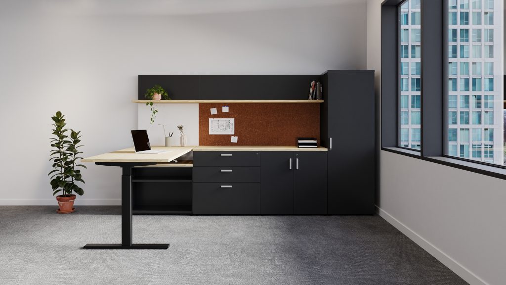 Freestanding height-adjustable desk with storage beneath. Shelf above a PET tackboard and whiteboard with wardrobe beside.