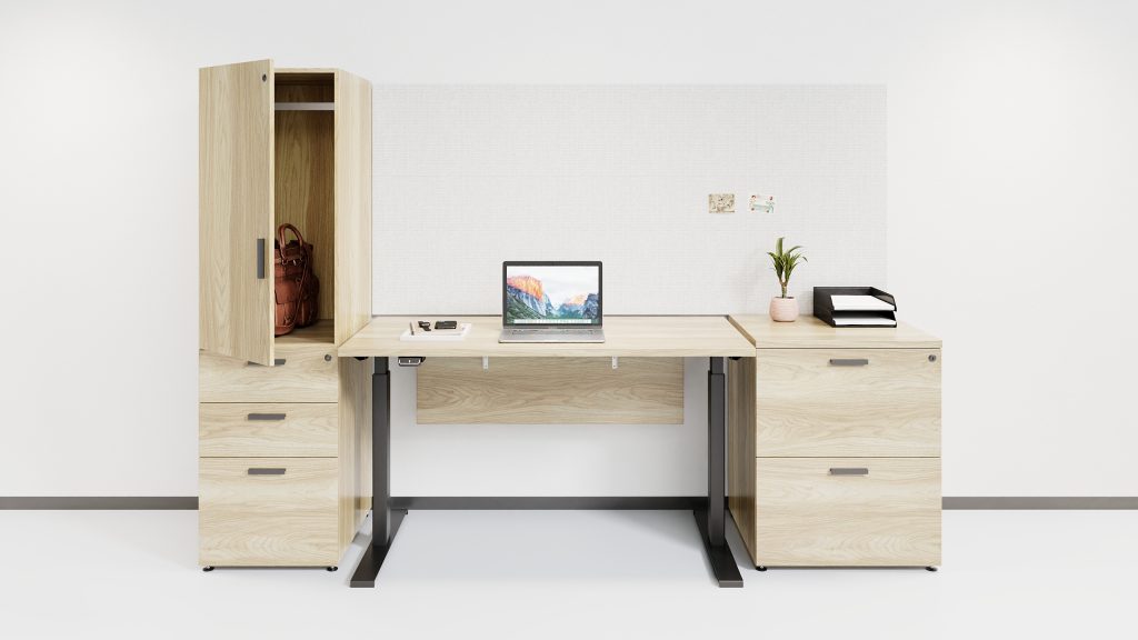 Free standing height-adjustable desk beside pedestal storage with a wardrobe overtop and file, file storage.